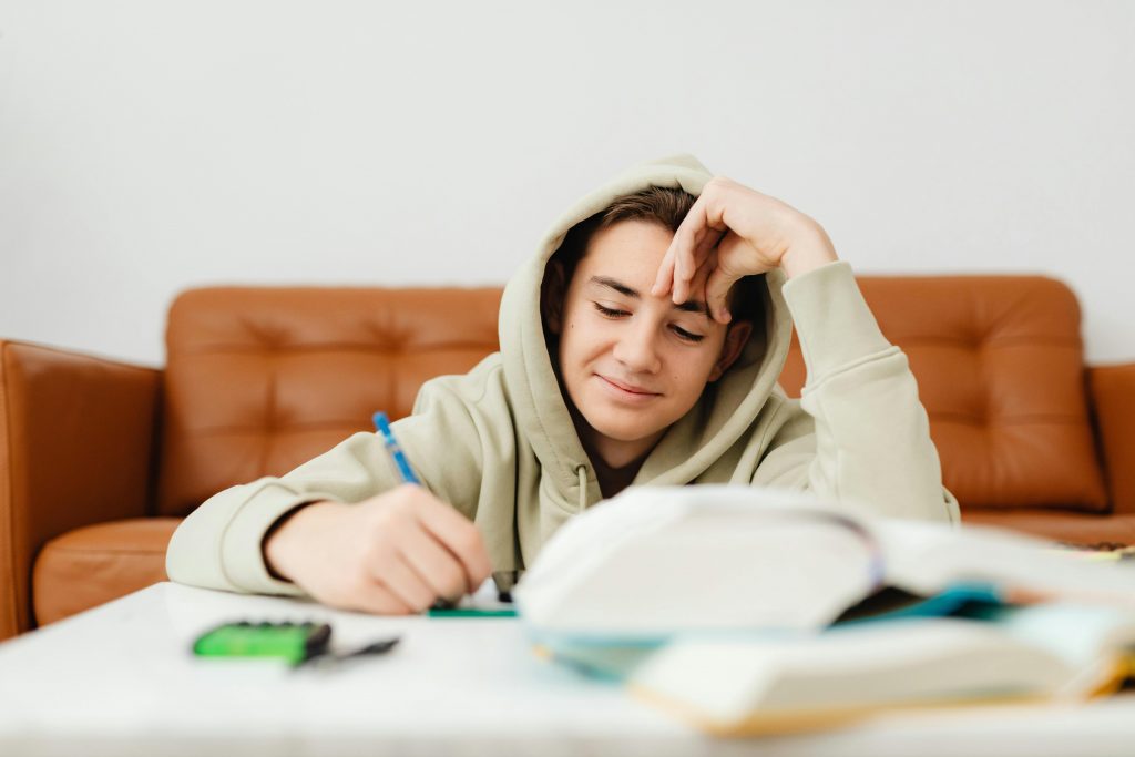 Boy smiling while writing out English vocabulary