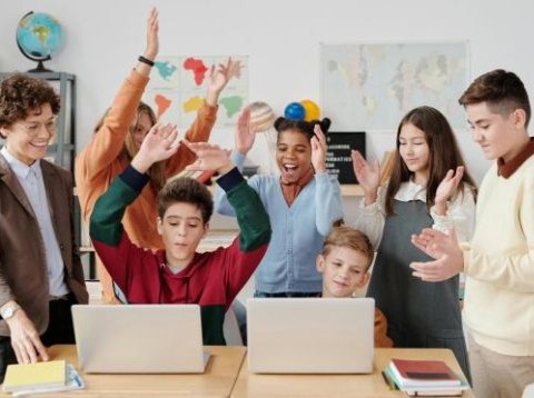 A group of students playing English learning games on laptops